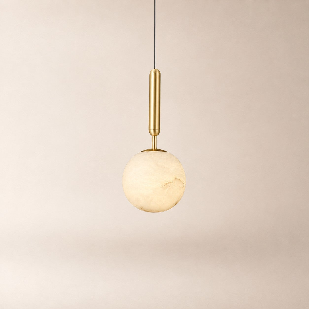 Velriq pendant light with a spherical natural alabaster shade and warm brass accents