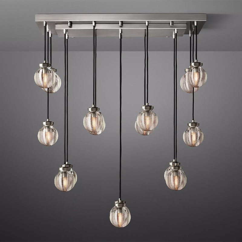 Linear chandelier with brushed nickel frame and ten ribbed glass sphere pendants on gray background.